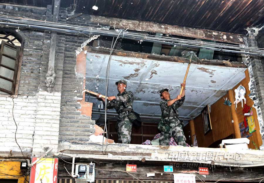 4月21日上午，記者在蘆山地震中心災區太平鎮，攝下了13集團軍某炮兵團官兵興清理廢墟路障的情景。