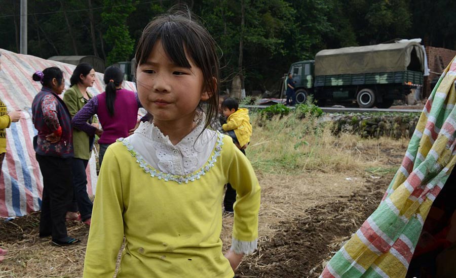 4月21日，住在簡易帳篷裡的高夢思。4月20日，蘆山縣龍門鄉(xiāng)，地震發(fā)生時9歲的高夢思在和4歲的弟弟在家，一塊木板砸在弟弟的頭上，高夢思一把抱起弟弟到了安全的地方，檢查后弟弟只是受了些輕傷。中新社發(fā) 張元 攝 