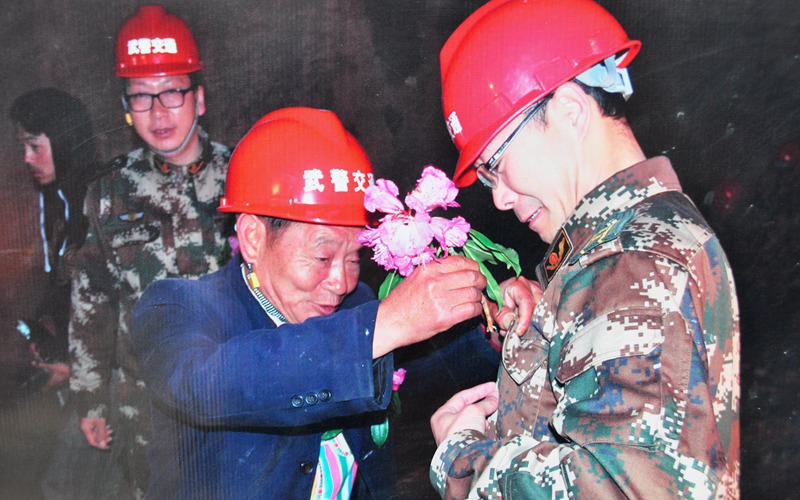 隧道貫通之際，高德榮滿心欣喜為武警戰(zhàn)士獻(xiàn)上杜鵑花。